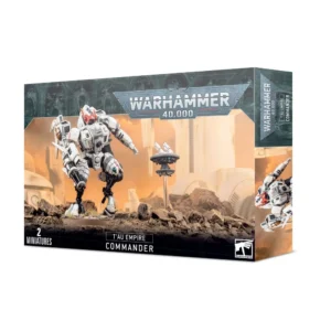 Photo de l'emballage de la boîte de figurine du Commandant de l’Empire T’au sous le logo officiel "WARHAMMER 40,000". L'illustration montre une imposante exo-armure de combat blanche et noire avec des marquages orange et des optiques rouges. Elle est positionnée de profil sur un terrain rocheux et désertique sous un ciel embrasé de couleur orange. Un drone de défense lévite à ses côtés. En bas à gauche, l'inscription "2 MINIATURES" est visible.