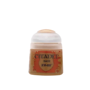Un pot de peinture acrylique Citadel de forme cylindrique, photographié de face sur un fond blanc uni. À travers le flacon en plastique transparent, on distingue une peinture opaque de couleur ocre-brun ou beige foncé. L'étiquette centrale présente un motif de blason rouge orangé avec des effets de projections de peinture. Le texte noir sur l'étiquette indique la marque "CITADEL", la mention de gamme "BASE" et le nom du produit Base: XV-88. Le capuchon en plastique translucide est surmonté d'une pastille de plastique de la même couleur ocre pour faciliter son identification.