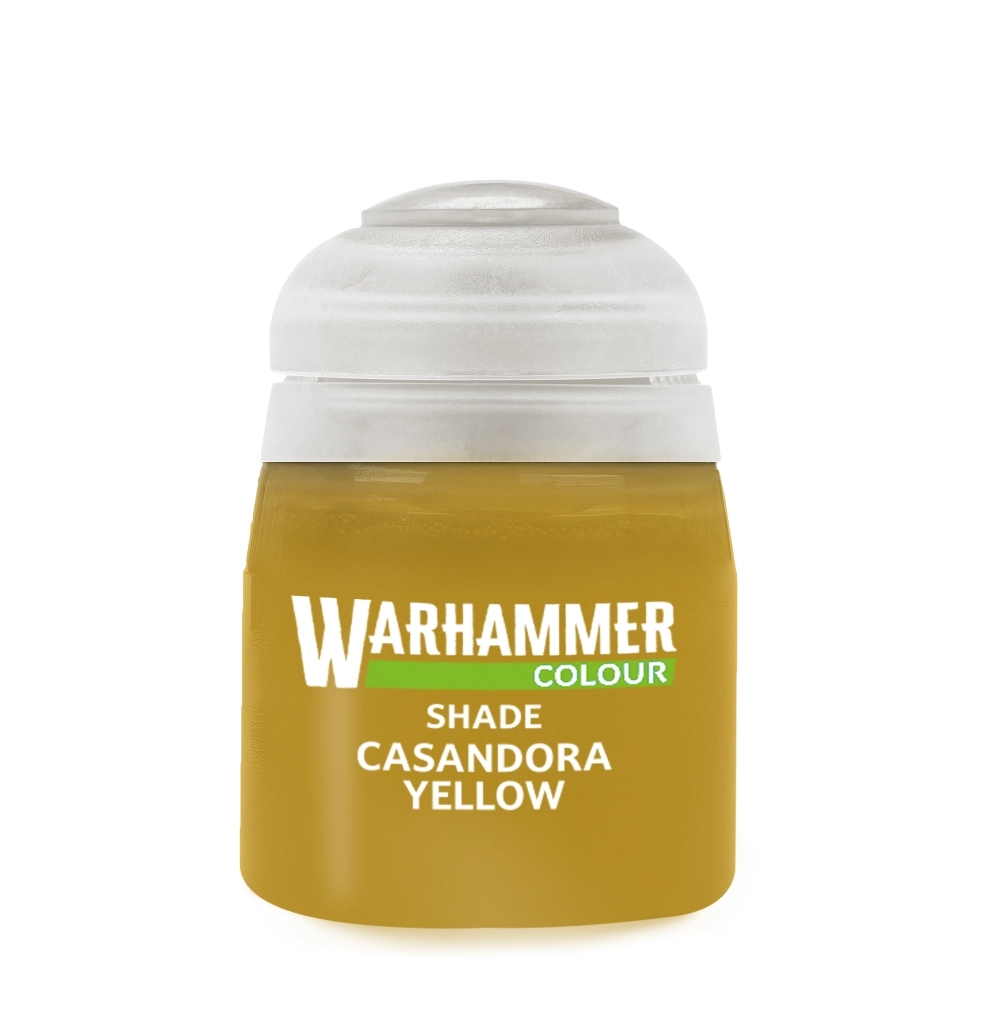 Photo de face d'un pot de peinture en plastique transparent de la gamme Shade: Casandora Yellow présenté sur un fond blanc neutre. Le pot laisse apparaître un contenu liquide de type lavis de couleur jaune ocre ou moutarde dorée. Les inscriptions sur l'avant affichent le logo blanc « WARHAMMER COLOUR » souligné d'un bandeau vert horizontal, placé juste au-dessus des mentions « SHADE » et « CASANDORA YELLOW » écrites en lettres capitales blanches. Le pot est refermé par son capuchon à charnière en plastique blanc translucide.
