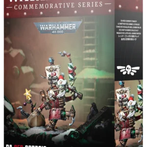 Photographie de la boîte d'emballage de la figurine de collection Boît’boy de Gobbo le Rouge. Le haut de la boîte arbore un bandeau bordeaux avec l'inscription blanche "Warhammer Commemorative Series", surmontant le logo officiel gris et bleu de Warhammer 40,000. L'illustration centrale présente la figurine assemblée et peinte posée sur un sol enneigé sous une lueur verte : un petit Grot vert à la peau ridée portant un bonnet de Noël rouge et blanc sourit de toutes ses dents. Il chevauche un automate métallique rouge et rouillé doté d'un remontoir mécanique dans le dos et d'une tête carrée évoquant un soldat casse-noisette. Le Grot brandit un gros pétard festif rayé de rouge et vert dont la mèche fume, tandis qu'un petit sapin minimaliste orné d'une étoile dorée est planté à ses pieds. Le bas de la boîte noir indique "Da Red Gobbo's Tinboy" et "1 Citadel Miniature". Le rabat latéral droit affiche les traductions du nom, incluant le texte en français, au-dessus d'un gros plan du personnage.