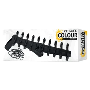 Vue de trois-quarts sur fond blanc d'une boîte de rangement Citadel Colour. Au centre, la Baguette à Bomber Citadel Colour est présentée avec sa structure en plastique noir munie de clips à ressort, accompagnée d'un petit tas d'élastiques noirs posés à gauche. L'emballage, au design moderne, présente des motifs d'éclaboussures gris clair, le logo "CITADEL COLOUR" mis en évidence par une tache de peinture jaune, et le texte "SPRAY STICK" en dessous. Sur la tranche droite de la boîte, les inscriptions "CITADEL COLOUR" et "SPRAY STICK" sont écrites verticalement en noir.