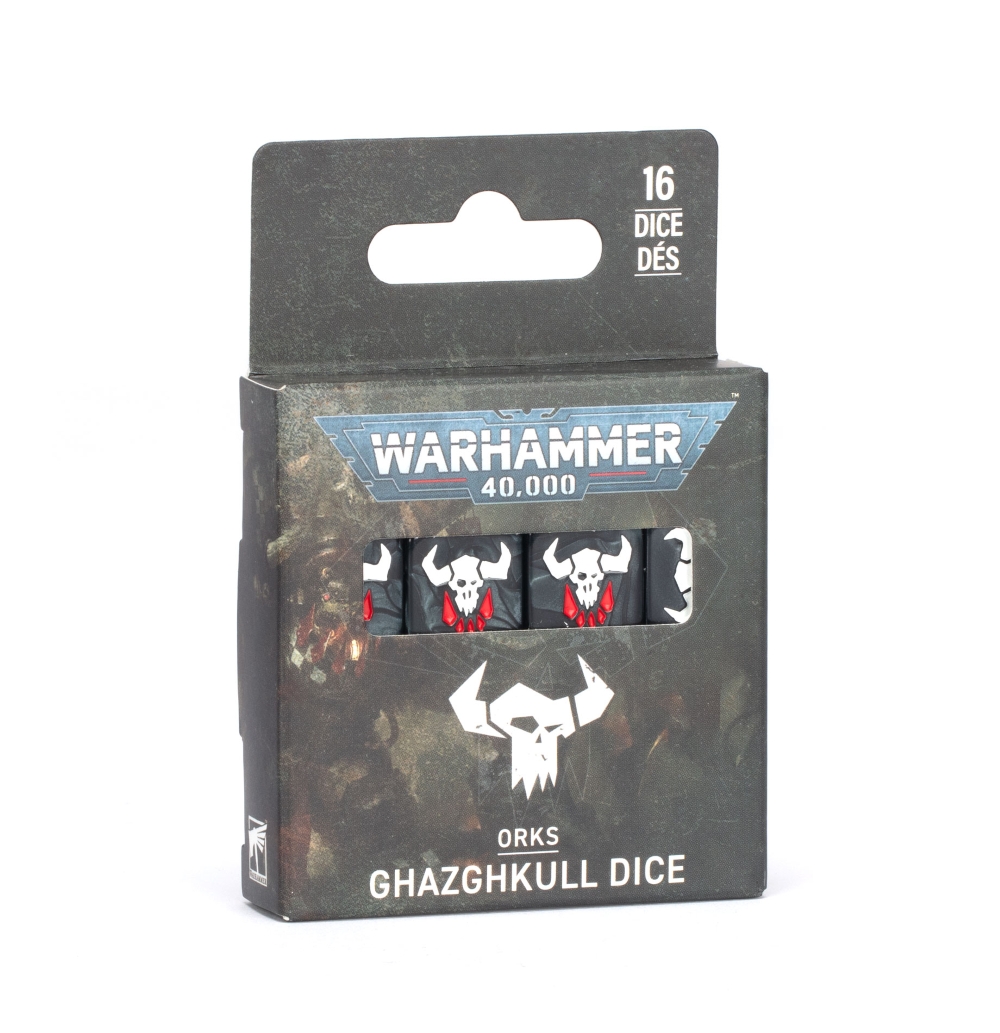 Photographie sur fond blanc de la boîte de produit officielle contenant les Dés de Ghazghkull pour Warhammer 40,000. Le packaging cartonné est noir et de forme rectangulaire, surmonté d'une languette de suspension portant l'inscription "16 DICE DÉS" en blanc. Sur la face avant sombre, le logo bleu et blanc "Warhammer 40,000" domine une ouverture horizontale vitrée qui laisse entrevoir une rangée de dés noirs décorés d'un crâne cornu Ork blanc aux dents rouges pointues. Juste en dessous, le logo de la faction Ork (un grand crâne blanc stylisé avec des cornes) surmonte les inscriptions textuelles blanches "ORKS" et "GHAZGHKULL DICE". Le petit logo de Citadel miniatures est imprimé discrètement dans le coin inférieur gauche.