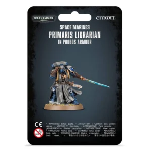 Emballage de type blister officiel à fond noir texturé pour le jeu Warhammer 40,000. La partie supérieure présente les logos « WARHAMMER 40,000 » à gauche et « CITADEL » à droite, surplombant l'inscription blanche en capitales « SPACE MARINES PRIMARIS LIBRARIAN IN PHOBOS ARMOUR ». Au centre, l'illustration montre la figurine peinte de l'Archiviste Primaris en armure Phobos. Le personnage, campé sur un socle rond terreux, porte une armure bleu saphir recouverte d'un grand manteau de camouflage gris à motifs géométriques et d'un capuchon. Il brandit de sa main gauche une épée de force à la lame bleu cyan lumineuse, tandis que sa main droite gantée de cuir marron est portée à son casque dans une posture de concentration psychique. Les avertissements de sécurité et le logo CE sont visibles au bas du carton.