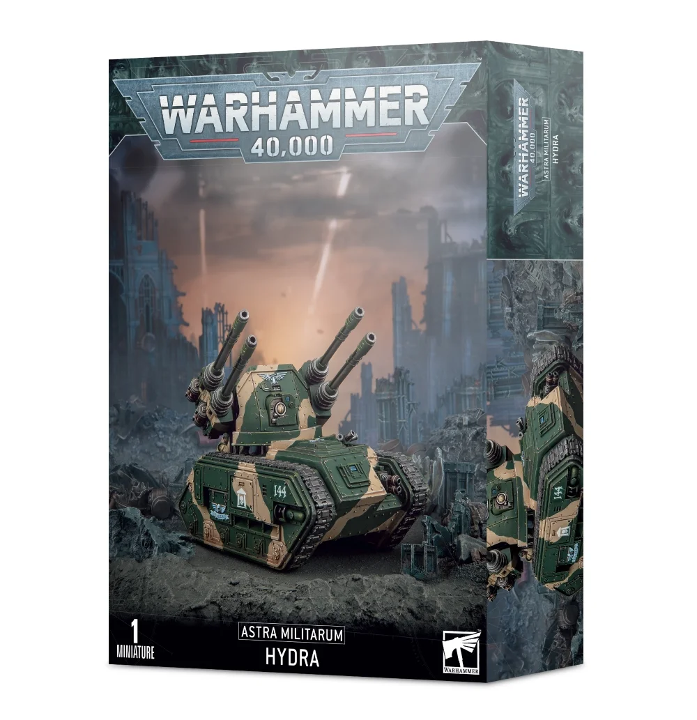 Boîte d'emballage officielle d'une figurine de véhicule pour le jeu de stratégie Warhammer 40,000, présentée de trois-quarts. Le grand logo argenté de Warhammer 40,000 domine la partie supérieure, incrusté sur une bordure supérieure gris foncé sculptée de reliefs de visages hurlants. L'illustration centrale met en scène le char de défense antiaérienne Hydra entièrement assemblé et peint. Le blindé de l'Astra Militarum arbore un châssis lourd vert kaki monté sur des chenilles métalliques et affiche des marquages militaires blancs, dont le numéro 251. Sa tourelle ouverte est surmontée d'une impressionnante batterie de quatre longs autocanons antiaériens jumelés noirs et d'une parabole de ciblage radar, tandis qu'un bolter lourd de coque est visible à l'avant. Le blindé progresse sur un sol de ruines urbaines industrielles et de gravats, sous un ciel ténébreux saturé d'explosions orangées et de traînées de fumée blanche. En bas au centre, un encadré noir épuré indique les inscriptions blanches "ASTRA MILITARUM HYDRA", flanquées de la mention "1 MINIATURE" à gauche et du logo blanc officiel de Warhammer Citadel à droite. Le rabat latéral droit, d'une teinte gris-bleu sombre, montre un aperçu vertical incliné du même véhicule.