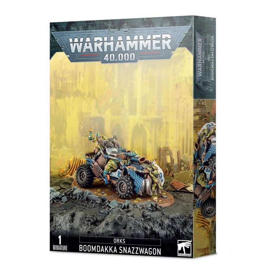 Boîte d'emballage officielle de Warhammer 40,000 au format vertical, présentant une figurine de véhicule pour l'armée des Orks. L'illustration principale, sur un fond jaune brumeux de ruines industrielles, met en scène un véhicule de course blindé et lourdement armé connu sous le nom de Boomdakka Snazzwagon. Ce bolide, orné de motifs à damiers bleus et blancs, est conduit par un Ork à la peau verte, tandis qu'un Grot est accroché à l'avant du véhicule au milieu d'une carrosserie en métal usé et de pointes agressives. Le logo officiel argenté "WARHAMMER 40,000" domine le haut de la boîte, et la bande noire inférieure indique "1 MINIATURE" ainsi que "ORKS BOOMDAKKA SNAZZWAGON".