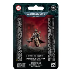 Emballage sous blister officiel d'une figurine de personnage pour le jeu de stratégie Warhammer 40,000, présenté de face avec une fente d'accroche au sommet. La partie supérieure arbore le logo officiel argenté Warhammer 40,000 sur fond gris texturé représentant des visages hurlants. L'illustration centrale met en scène l'Inquisitrice Greyfax entièrement assemblée et peinte. Le personnage porte une armure énergétique baroque aux tons argentés et ornements dorés, une longue cape pourpre fluide et un chapeau haut-de-forme typique des chasseurs de sorcières surmonté d'une petite icône. Elle brandit une imposante arbalète de condamnation de sa main droite. La figurine est positionnée sur un socle rocheux sombre, devant un arrière-plan baigné d'un dégradé rouge vif embrumé laissant deviner des silhouettes de bâtiments gothiques. En bas au centre, un encadré noir affiche les mentions "IMPERIAL AGENTS" et "INQUISITOR GREYFAX", suivies de ses traductions multilingues, dont "INQUISITRICE GREYFAX". En bas à gauche figure la mention "1 CITADEL MINIATURE".