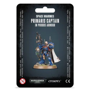 Photographie du packaging officiel d'une figurine Citadel pour le jeu Warhammer 40,000. Le fond de l'emballage est noir avec des bordures texturées. Au centre, un encadré montre la figurine assemblée et peinte du Capitaine en armure Phobos (primaris captain in phobos armour). Il s'agit d'un Space Marine vêtu d'une armure assistée bleue (chapitre des Ultramarines), équipé d'une cape blanche à doublure marron, d'un gantelet de combat et d'une carabine bolter automatique de tireur d'élite relevée vers le haut. Le personnage, au crâne rasé avec une optique cybernétique sur l'œil droit, se tient debout sur un socle texturé simulant un sol rocheux. Au-dessus de l'illustration, l'inscription en blanc indique « SPACE MARINES PRIMARIS CAPTAIN IN PHOBOS ARMOUR ». En bas, les logos officiels « WARHAMMER 40,000 » et « CITADEL » sont visiblement imprimés aux côtés des avertissements de sécurité.