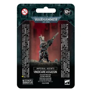Emballage sous blister officiel d'une figurine de personnage pour le jeu de stratégie Warhammer 40,000, présenté de face avec une fente d'accroche au sommet. La partie supérieure est ornée du logo officiel argenté Warhammer 40,000 sur fond gris texturé de visages hurlants. L'illustration centrale met en scène l'Assassin Vindicare entièrement assemblé et peint. Le tireur d'élite porte une combinaison furtive noire moulante (synsking) avec des sangles et des protections rouges. Il est masqué et équipé d'un viseur cybernétique blanc et rouge sur son œil droit, tout en s'appuyant contre un pan de pilier en ruine beige. Il tient fermement un immense fusil de précision Exitus équipé d'un silencieux et d'une lunette de visée, orienté vers le haut à droite. Le personnage se tient sur un sol rocheux sombre parsemé de débris et d'un petit crâne. L'arrière-plan de l'illustration est un dégradé de rouge vif et de silhouettes de bâtiments gothiques. En bas au centre, un encadré noir affiche les mentions "IMPERIAL AGENTS" et "VINDICARE ASSASSIN", suivies de ses traductions dont "ASSASSIN VINDICARE". En bas à gauche figure la mention "1 CITADEL MINIATURE".