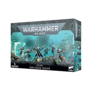 Boîte d'emballage officielle d'une unité de figurines pour le jeu de stratégie Warhammer 40,000, présentée de trois-quarts. Le grand logo argenté de Warhammer 40,000 domine la partie supérieure, incrusté sur une bordure supérieure gris foncé sculptée de reliefs de visages hurlants. L'illustration centrale met en scène une Troupe d'Arlequins (intitulée Harlequin Troupe en anglais) entièrement assemblée et peinte. On y observe 6 guerriers acrobates de la faction Aeldari (sous-faction Arlequins) adoptant des poses dynamiques et théâtrales de combat. Ils portent des manteaux longs aux motifs asymétriques de losanges noirs, blancs et violets, des masques lisses argentés ou dorés, et des combinaisons bicolores. L'un des personnages au premier plan effectue une pirouette, tandis que ses compagnons manient de fines épées énergétiques, des pistolets à fusion et des pistolets shuriken noirs et rouges. L'unité progresse au milieu de ruines d'un temple extraterrestre, devant un arrière-plan mystique baigné d'une lueur turquoise. En bas au centre, un encadré noir épuré indique les inscriptions blanches "AELDARI HARLEQUIN TROUPE", flanquées de la mention "6 MINIATURES" à gauche et du logo blanc officiel de Warhammer Citadel à droite. Le rabat latéral droit, d'une teinte gris-bleu sombre, montre un aperçu vertical de l'un des Arlequins sous le même angle.