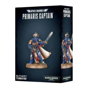 Vue de trois quarts de la boîte de figurine officielle pour le jeu Warhammer 40,000. L'emballage arbore un design moderne gris foncé et noir texturé. En haut au centre, les inscriptions blanches en lettres capitales indiquent « SPACE MARINES PRIMARIS CAPTAIN » sous un logo d'ailes impériales. L'illustration centrale met en scène la figurine peinte d'un Space Marine Captain debout sur un socle de terre et d'herbe, se détachant sur un fond dégradé bleu nuit. Le guerrier est revêtu de l'armure assistée bleu saphir des Ultramarines avec des ornements dorés, une longue cape blanche et une auréole de fer dorée surmontant un cimier à plumes rouge et blanc. De sa main droite, il tient un fusil bolter lourd équipé d'une lunette, et brandit une épée énergétique de sa main gauche levée. Au bas de la boîte, on retrouve la mention blanche « 1 CITADEL MINIATURES » à gauche et le logo officiel métallique « WARHAMMER 40,000 » à droite.
