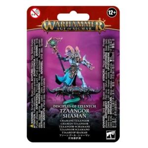 Photo de présentation sur fond blanc du blister de packaging du Chaman Tzaangor. L'emballage au fond violet vif et magenta est surmonté au sommet du logo doré et bleu "WARHAMMER AGE OF SIGMAR". L'illustration centrale présente la figurine peinte d'un sorcier hybride à la peau bleue et à tête d'oiseau coiffée de cornes. Vêtu d'une robe bleue et d'une armure ornée, il tient un bâton sorcier au sommet duquel brille une relique verte, et flotte sur un Disque de Tzeentch métallique propulsé par des flammes magiques vertes. En bas, le texte indique "DISCIPLES OF TZEENTCH TZAANGOR SHAMAN" suivi de la traduction "CHAMANE TZAANGOR". Les logos de sécurité "0-3" et "12+" encadrent la partie supérieure, tandis que le logo "WARHAMMER" figure dans le coin inférieur droit.