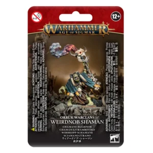 Visuel du blister de présentation Warhammer Age of Sigmar pour la figurine du Chamane Bizarnob de la faction Orruk Warclans. L'emballage affiche en haut le logo officiel doré "Warhammer Age of Sigmar" sur un fond rouge. L'illustration centrale met en scène un sorcier Orruk à la peau verte se tenant sur un sol rocailleux, vêtu d'une cape bleue foncée et de fétiches en os. Il brandit de ses deux mains un grand bâton surmonté d'un crâne cornu d'où s'échappe une épaisse fumée magique aux teintes bleues et rouges. En bas du blister figurent les inscriptions "ORRUK WARCLANS WEIRDNOB SHAMAN" ainsi que ses traductions, encadrées par de multiples avertissements légaux.