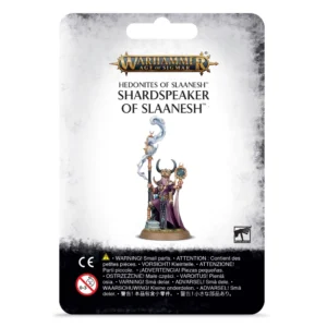 Photo de présentation sur fond blanc du blister de packaging du Shardspeaker of Slaanesh. L'emballage au fond blanc marbré est surmonté au sommet du logo doré et bleu "WARHAMMER AGE OF SIGMAR". L'illustration centrale présente la figurine peinte d'un sorcier vêtu d'une longue robe violette et rose, coiffé d'un masque doré à cornes. Il tient un sceptre duquel s'échappe une volute de fumée bleue et élève un miroir arcanique encadré d'or dans sa main gauche. En haut, le texte indique "HEDONITES OF SLAANESH SHARDSPEAKER OF SLAANESH". Le coin inférieur droit comporte le logo officiel "WARHAMMER", tandis que des avertissements de sécurité et le logo CE figurent sur le bandeau noir au bas de l'emballage.