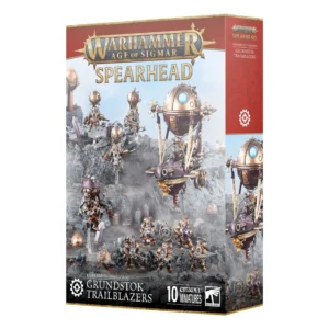 Boîte de produit officielle du kit de figurines Fer de Lance: Magnats Kharadrons – Défricheurs Grundstok (Grundstok Trailblazers Spearhead) pour le jeu Warhammer Age of Sigmar. L'emballage vertical présente en haut le grand logo officiel Warhammer Age of Sigmar en lettres métalliques dorées sur une bannière rouge bordeaux, surmontant le mot SPEARHEAD. L'illustration centrale met en scène une armée de dix figurines peintes : un vaisseau volant blindé (Canonnière Grundstok) aux teintes cuivre et violette, quatre guerriers volants à ballons-hélices (Stratogardes) et cinq soldats au sol lourdement armés (Foudroyeurs Grundstok) évoluant sur un terrain rocheux gris. Le panneau latéral droit rouge bordeaux arbore le symbole de rouage blanc de la faction. En bas, le bandeau noir indique KHARADRON OVERLORDS GRUNDSTOK TRAILBLAZERS, accompagné de la mention 10 CITADEL MINIATURES et du logo carré blanc Citadel Warhammer à droite.