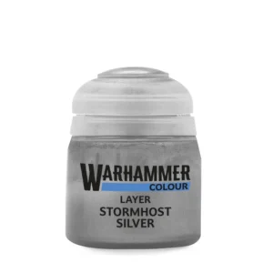 Un pot de peinture acrylique de 12 ml de la gamme Warhammer Colour, présenté de face sur un fond blanc épuré. Le flacon en plastique transparent laisse transparaître une peinture fluide de couleur argent brillant aux reflets métalliques scintillants. Le pot est scellé par un bouchon en plastique souple blanc semi-translucide, affichant une légère teinte grise au sommet. L'étiquette centrale, assortie à la couleur argentée de la peinture, affiche le logo noir et blanc "WARHAMMER COLOUR" souligné d'un bandeau bleu horizontal, suivi de la mention "LAYER" et du nom de la teinte "Layer: Stormhost Silver" écrit en lettres capitales noires bien lisibles.
