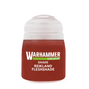 Photographie de face sur un fond blanc épuré d'un pot de peinture en plastique transparent de la gamme officielle Warhammer Colour. Le flacon laisse transparaître un lavis liquide de couleur brun-rougeâtre ou ocre chair, surmonté d'un capuchon hermétique en plastique blanc translucide. Au centre de l'étiquette noire, le logo blanc "WARHAMMER" surmonte un bandeau horizontal vert contenant l'inscription "COLOUR". Juste en dessous, les mentions textuelles imprimées en lettres capitales blanches indiquent de haut en bas la catégorie "SHADE" ainsi que le nom du produit, Shade: Reikland Fleshshade.