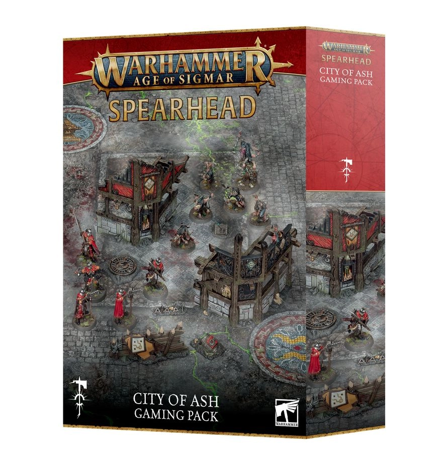 A three-quarter view of the closed retail box for the Spearhead: City of Ash Gaming Pack for Warhammer Age of Sigmar. The front of the box is crowned with the official gold "Warhammer Age of Sigmar" logo, immediately followed by the word "SPEARHEAD" in large gold capital letters. The main box illustration displays a detailed tabletop battlefield laid out on a grey cobblestone gaming mat, which is crisscrossed with glowing green magical energy fractures and decorated with circular floor crests. Miniature soldiers and rat-like Skaven warriors are shown fighting around ruined multi-story wooden buildings with distinct red and yellow timber frames, alongside stone barricades and small objective markers. At the bottom center, the text "CITY OF ASH GAMING PACK" is written in clean white letters next to the white Citadel miniatures logo. The right-side panel of the box is solid red and displays a white runic icon along with the product title.