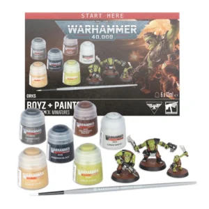 Le contenu complet du coffret Orks: Boyz + Set de Peinture est disposé sur un fond blanc, surmonté du logo Warhammer Community. À l'arrière-plan, la boîte affiche un bandeau Start Here, le logo Warhammer 40,000, et les inscriptions Orks, Boyz + Paints, Citadel Miniatures ainsi que la mention de volume 6 x 12ml e. Au premier plan à gauche, six pots de peinture Citadel Colour affichent clairement leurs étiquettes : Base Leadbelcher, Base Mournfang Brown, Base Corax White, Base Zandri Dust, Base Abaddon Black et Base Orruk Flesh. À droite, trois figurines de guerriers Orks peintes reposent sur des socles marron. Devant l'ensemble, un pinceau gris texturé porte l'inscription Warhammer Starter Brush.