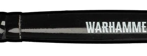 Photo du manche noir et des poils synthétiques d'un Pinceau Dry L Warhammer Tone Pro présentés à l'horizontale sur fond blanc. Le manche en bois laqué noir comporte le texte blanc sérigraphié « WARHAMMER PRO TONE DRY L » à côté du logo Warhammer Pro et d'un motif de code-barres. La tête carrée se compose de poils fermes de couleur crème, spécialement conçus pour la technique du brossage à sec.