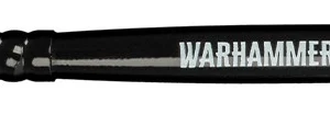Vue horizontale du manche laqué noir et de la tête d'un Pinceau Dry M Warhammer Tone Pro sur fond blanc. Le manche porte la mention sérigraphiée « WARHAMMER PRO TONE DRY M » à côté du logo officiel et d'un motif style code-barres. La touffe de poils synthétiques de couleur crème offre une forme arrondie et compacte adaptée au brossage à sec sur des figurines de taille intermédiaire.